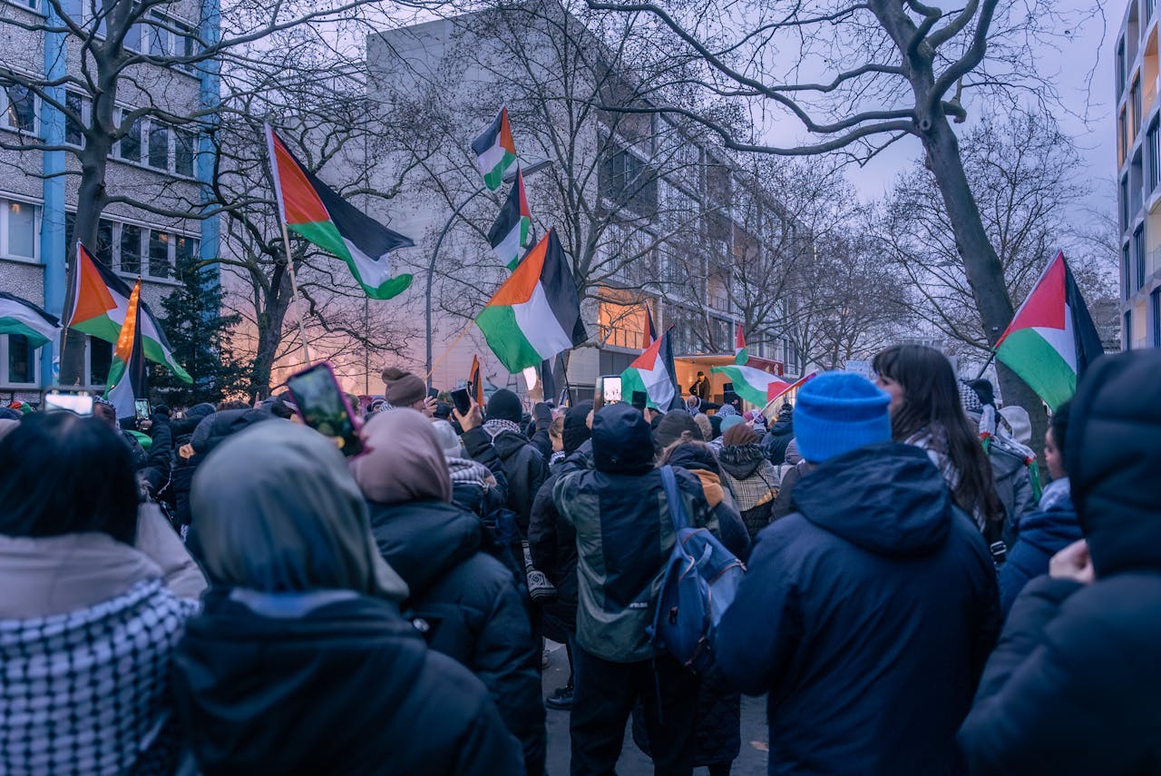 A peaceful protest in Berlin featuring Palestinian flags and diverse participants.